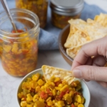 Dipping chips into a bowl of corn relish.