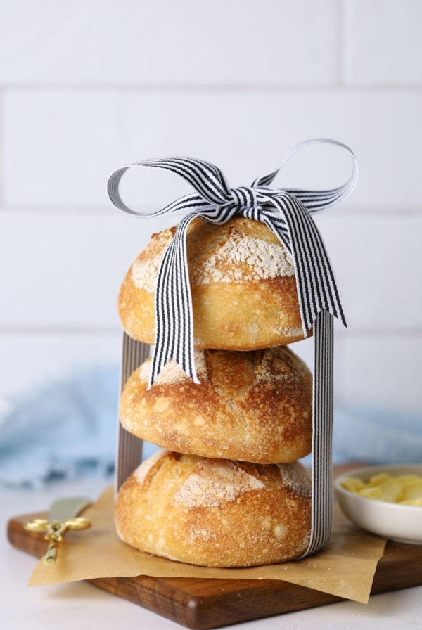 Three mini sourdough boules stacked and tied with a ribbon in a bow.