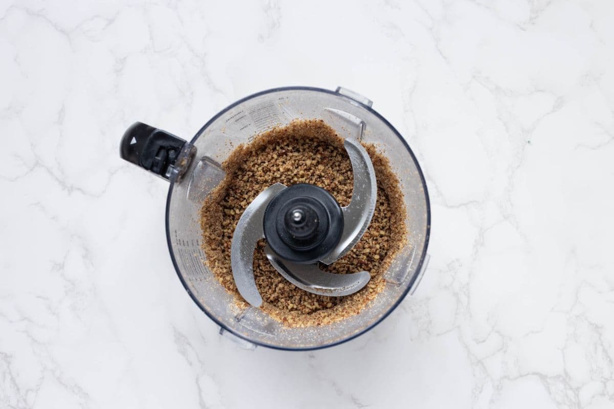 Blitzing the pecans in a food processor to make sourdough discard pecan sandies.