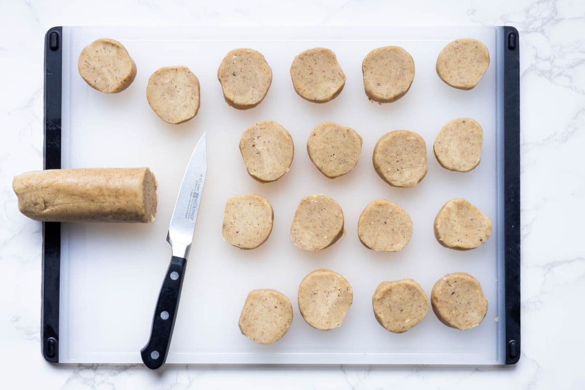 Cutting the dough log into cookies to make sourdough discard pecan sandies.