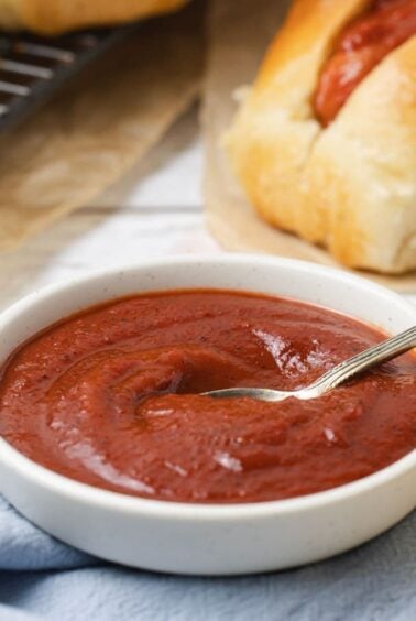 Close up of homemade ketchup with a spoon for serving.