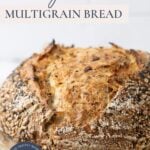 Load of multigrain sourdough bread on a piece of parchment paper with text overlay for a Pinterest Pin.