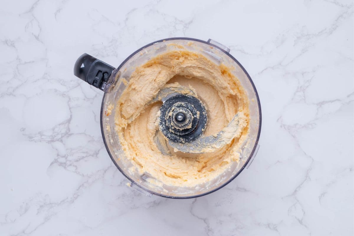 Ingredients for potted cheese blended in food processor.