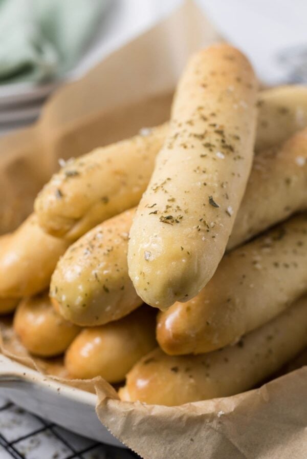 Close up of a soft sourdough breadstick to see fluffy texture and herb topping.