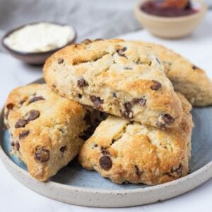 Close up of golden sourdough chocolate chip scones stacked on a plate.