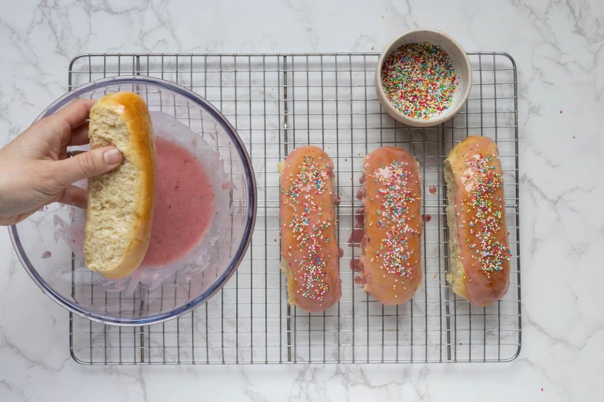 Adding sprinkles to glaze dipped buns to make the sourdough discard iced buns.