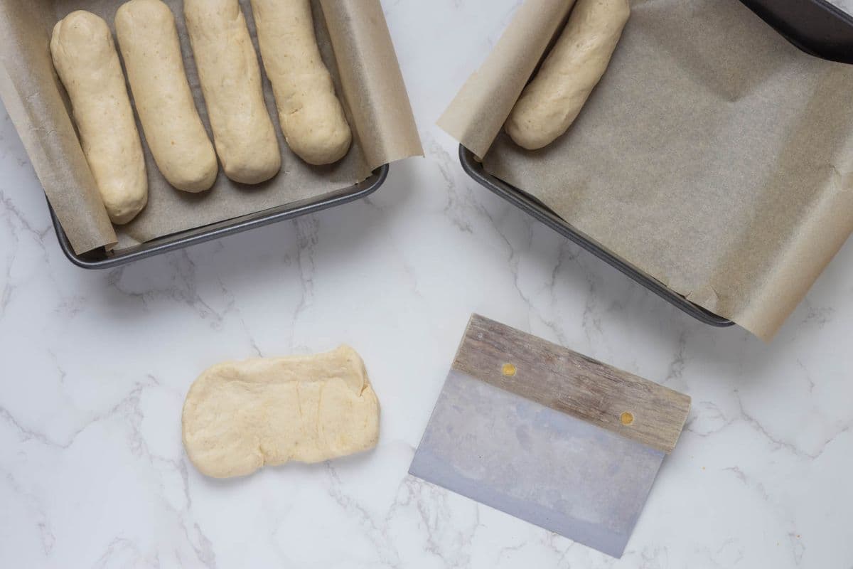 Shaping the dough and adding to the baking pans to make sourdough discard iced buns.