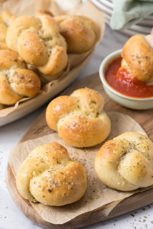 Sourdough discard garlic knots being dipped into marinara sauce for an appetizer.