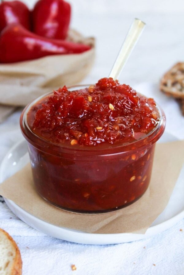 A jar of chili jam on a plate ready for serving.