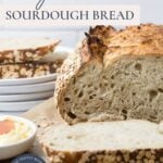 A photo of sourdough honey oat bread sliced for serving with text overlay for a Pinterest Pin image.