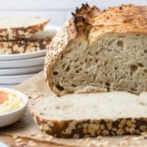 Close up of a sliced loaf of sourdough honey oat bread to show inside texture.