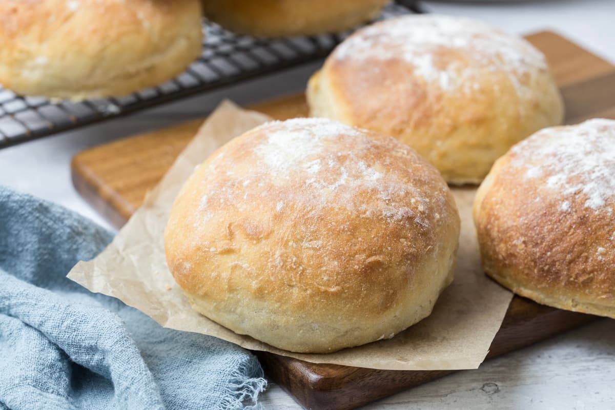Sourdough discard rolls on a wood block for serving.