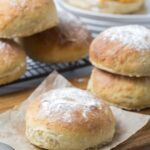 Sourdough discard rolls being used to make a sandwich with a sandwich in the background.