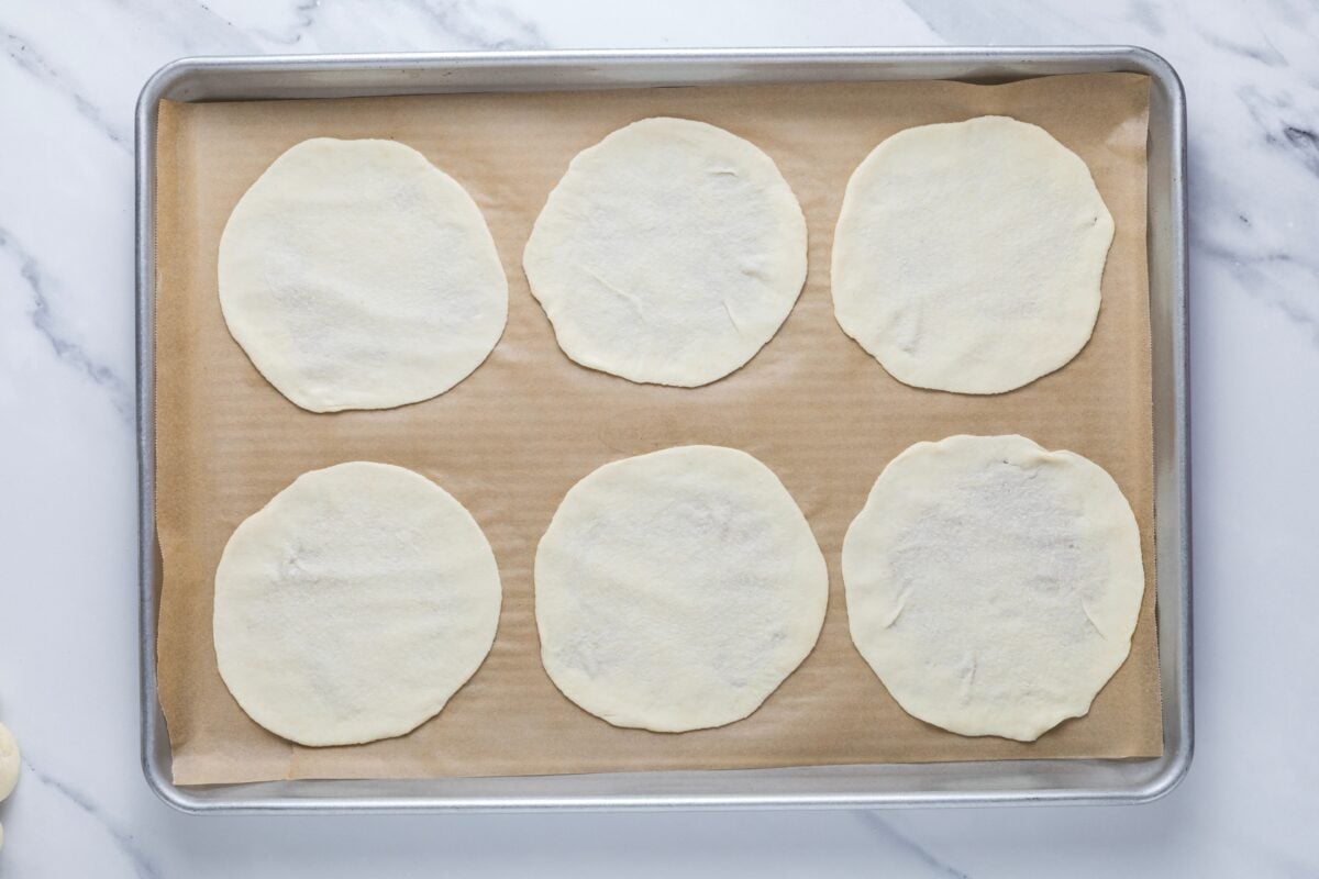 Sourdough parchment cracker dough on parchment lined baking sheet before placing in the oven.