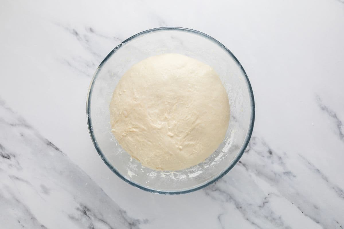 Simple sourdough focaccia bread dough in a glass mixing bowl.