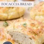 A sliced open loaf of simple sourdough focaccia bread on parchment paper with text overlay for a Pinterest Pin image.