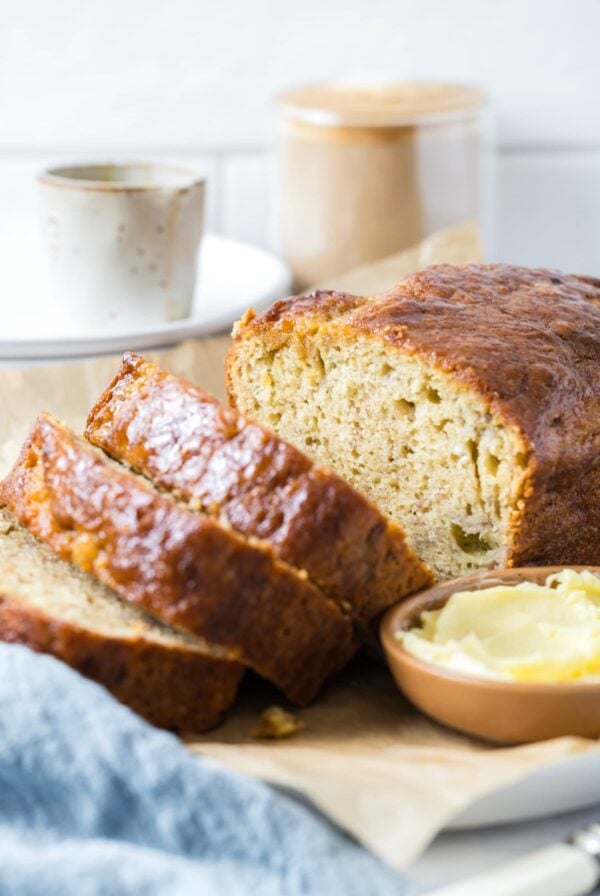 Serving a loaf of sourdough discard banana bread with butter for spreading.