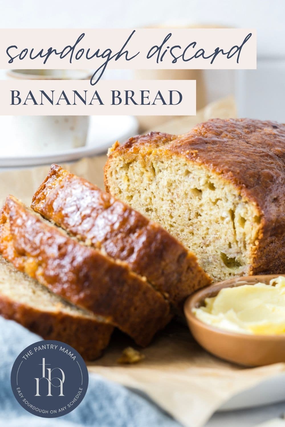 A sliced loaf of sourdough discard banana bread being served with butter with text overlay on top for a Pinterest image.