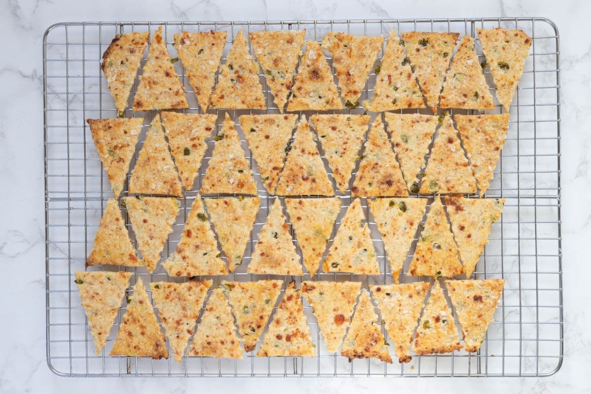Fresh baked sourdough jalapeño cheddar crackers cooling on a wire rack.