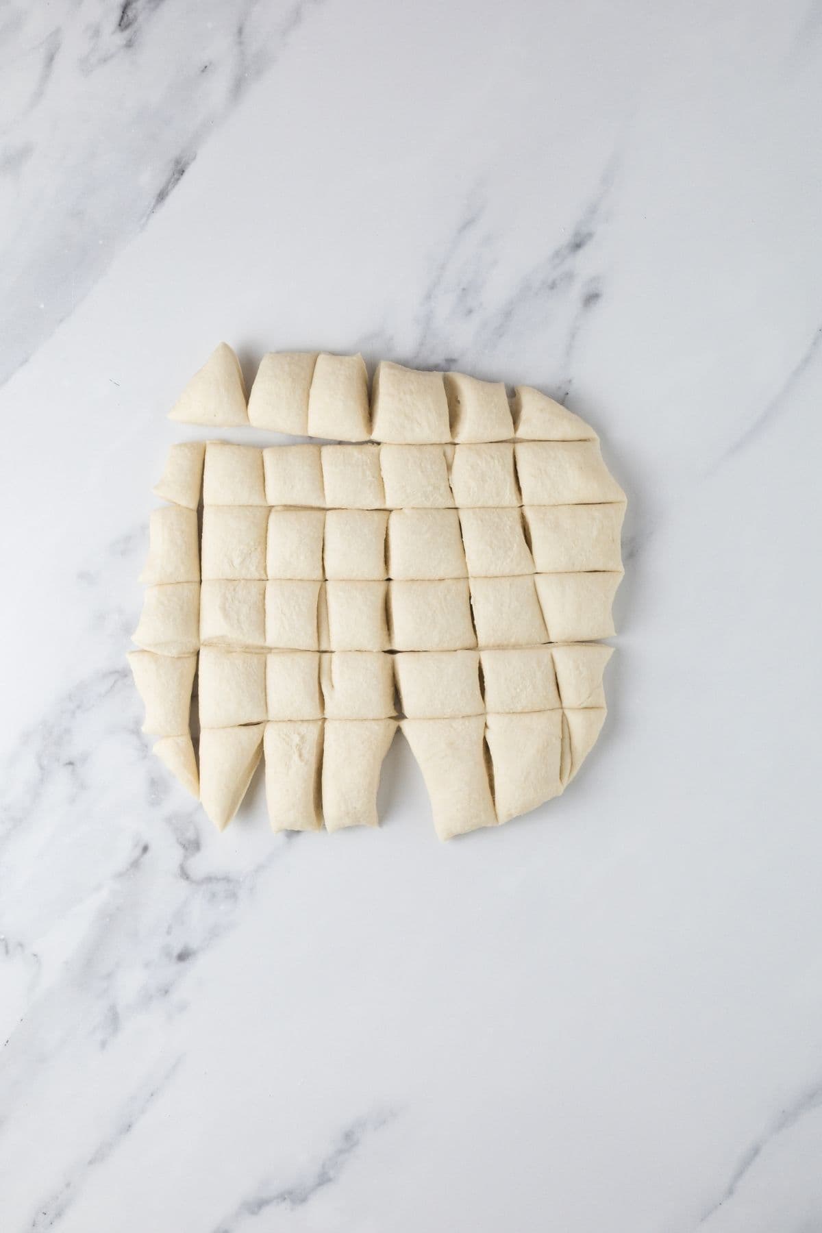 Dividing dough on counter into even pieces to make sourdough parchment crackers.
