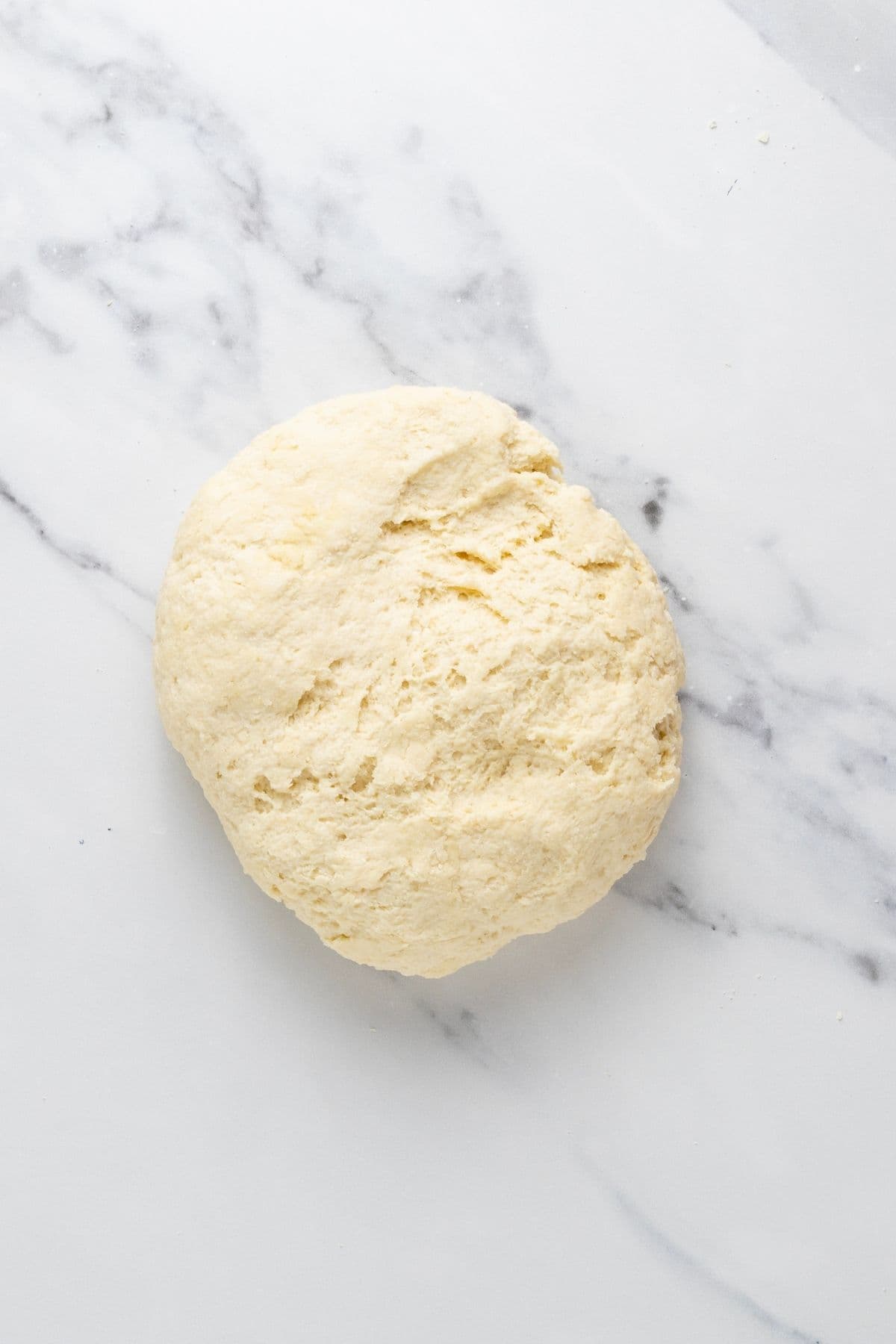 A ball of sourdough parchment cracker dough on the counter after a short fermentation.