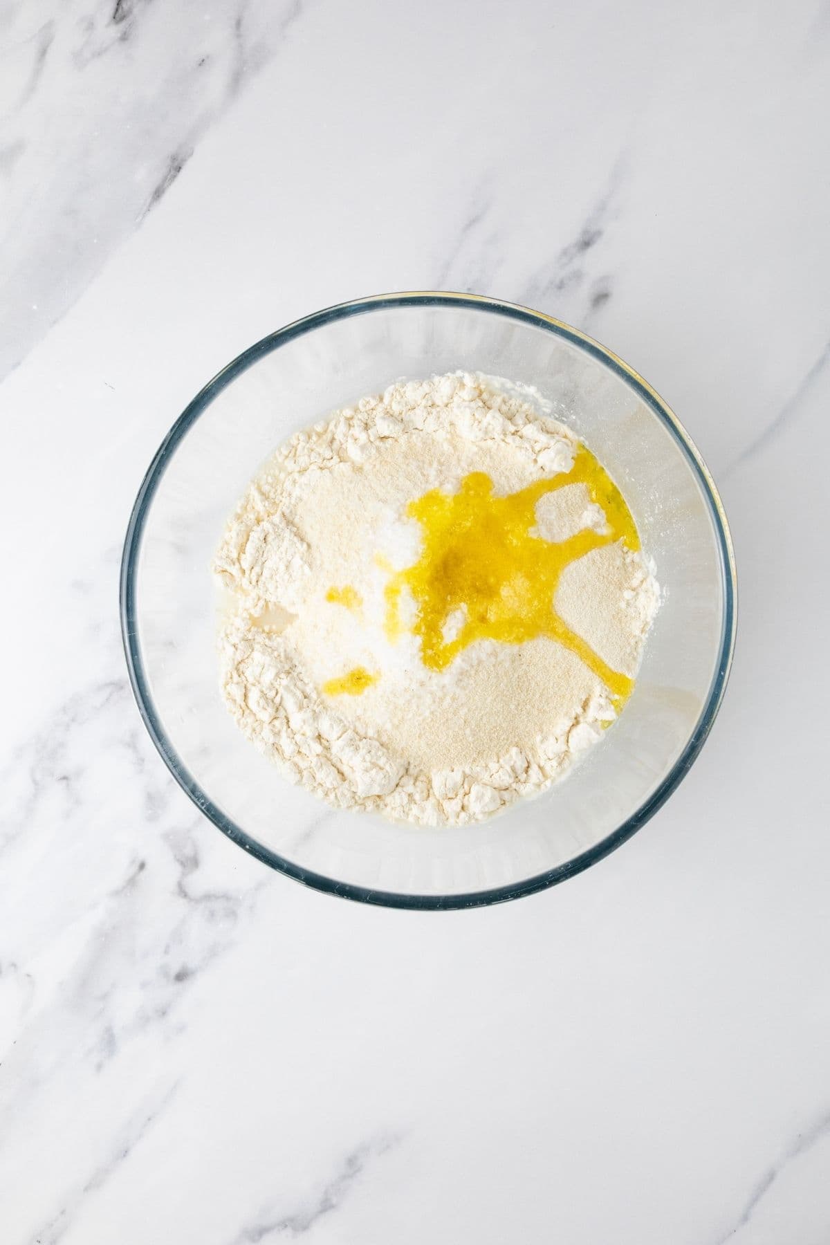 Ingredients for sourdough parchment crackers in a bowl for mixing.