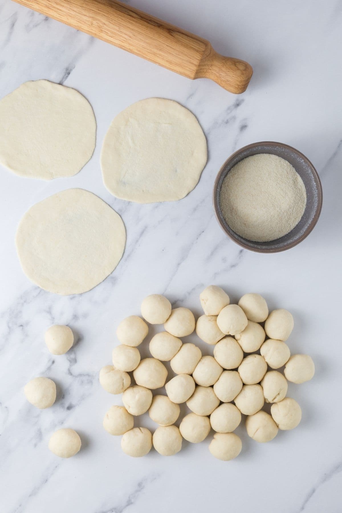 Sourdough parchment cracker dough on the counter to be rolled flat for the crackers.