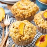 Close up of a sourdough peach cobbler muffin cooling on a wire rack.