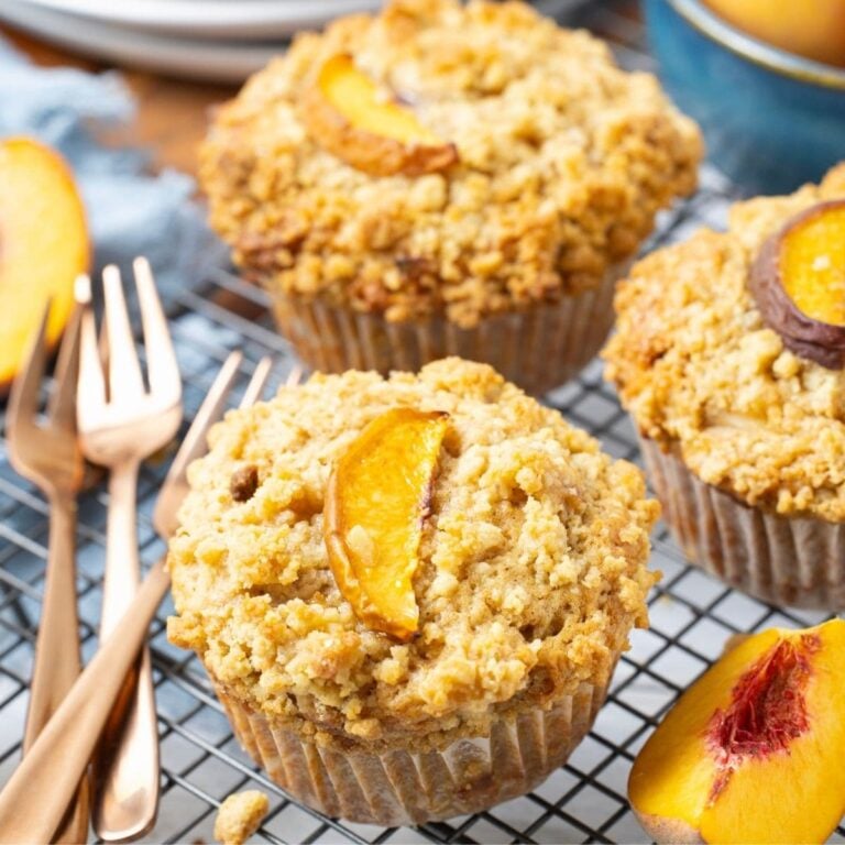 Close up of a sourdough peach cobbler muffin cooling on a wire rack.