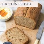 A loaf of sourdough zucchini bread being sliced and served with honey butter with text overlay for a Pinterest Pin image.