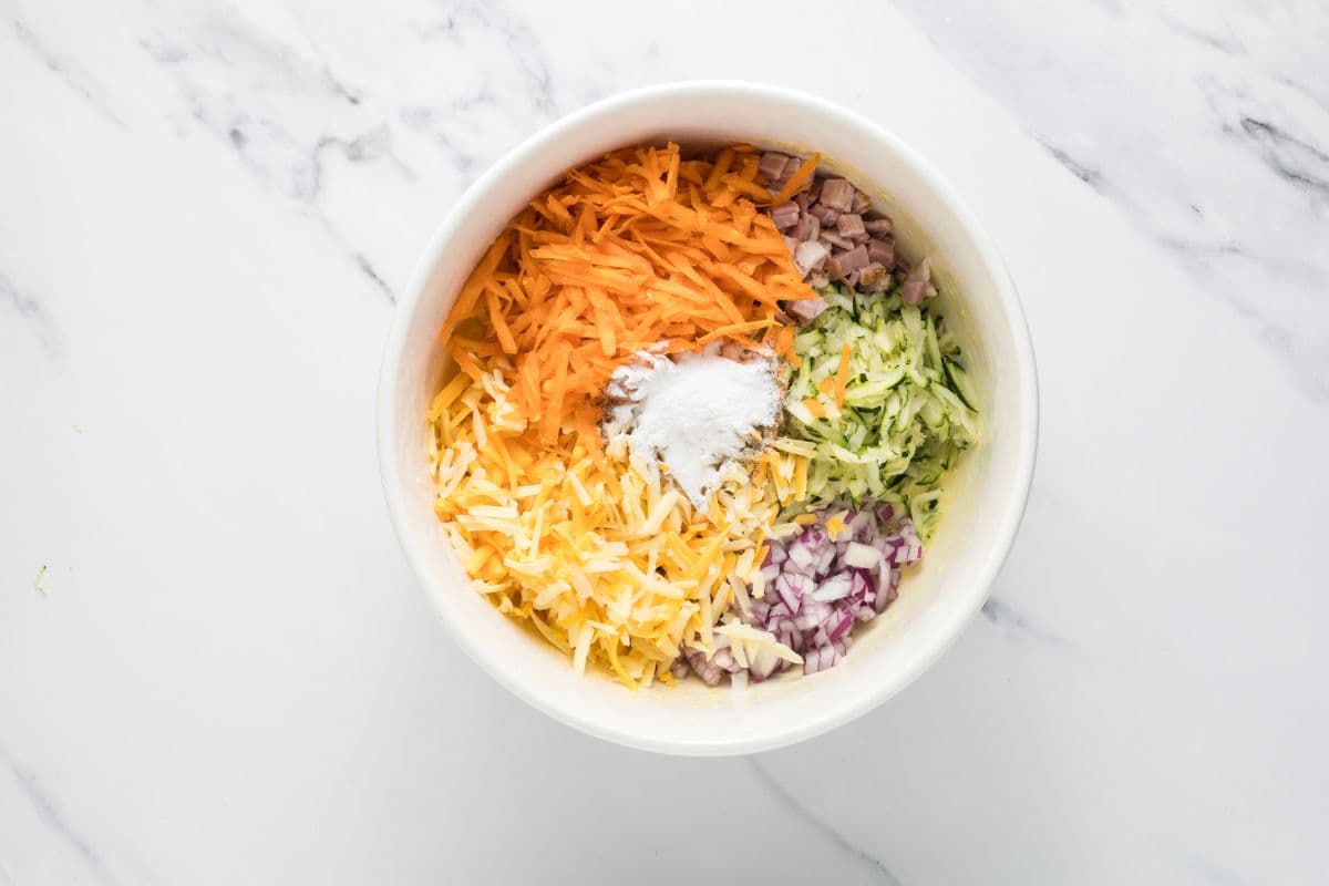 All ingredients in a mixing bowl just before mixing to make the batter for a sourdough zucchini slice.