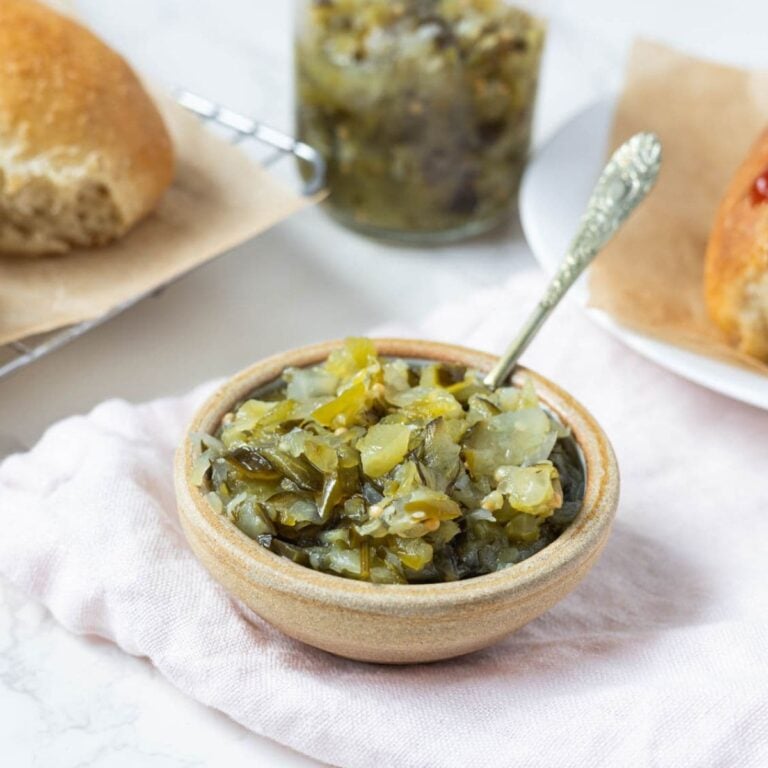 Close up of dill pickle relish in a serving bowl with a spoon.