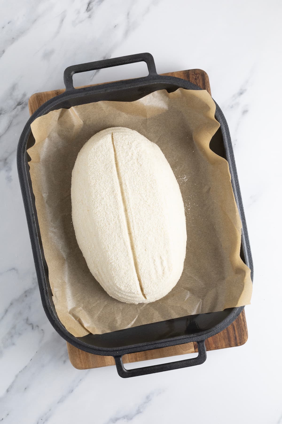 Shaped overnight sourdough bread dough with a center score before baking.