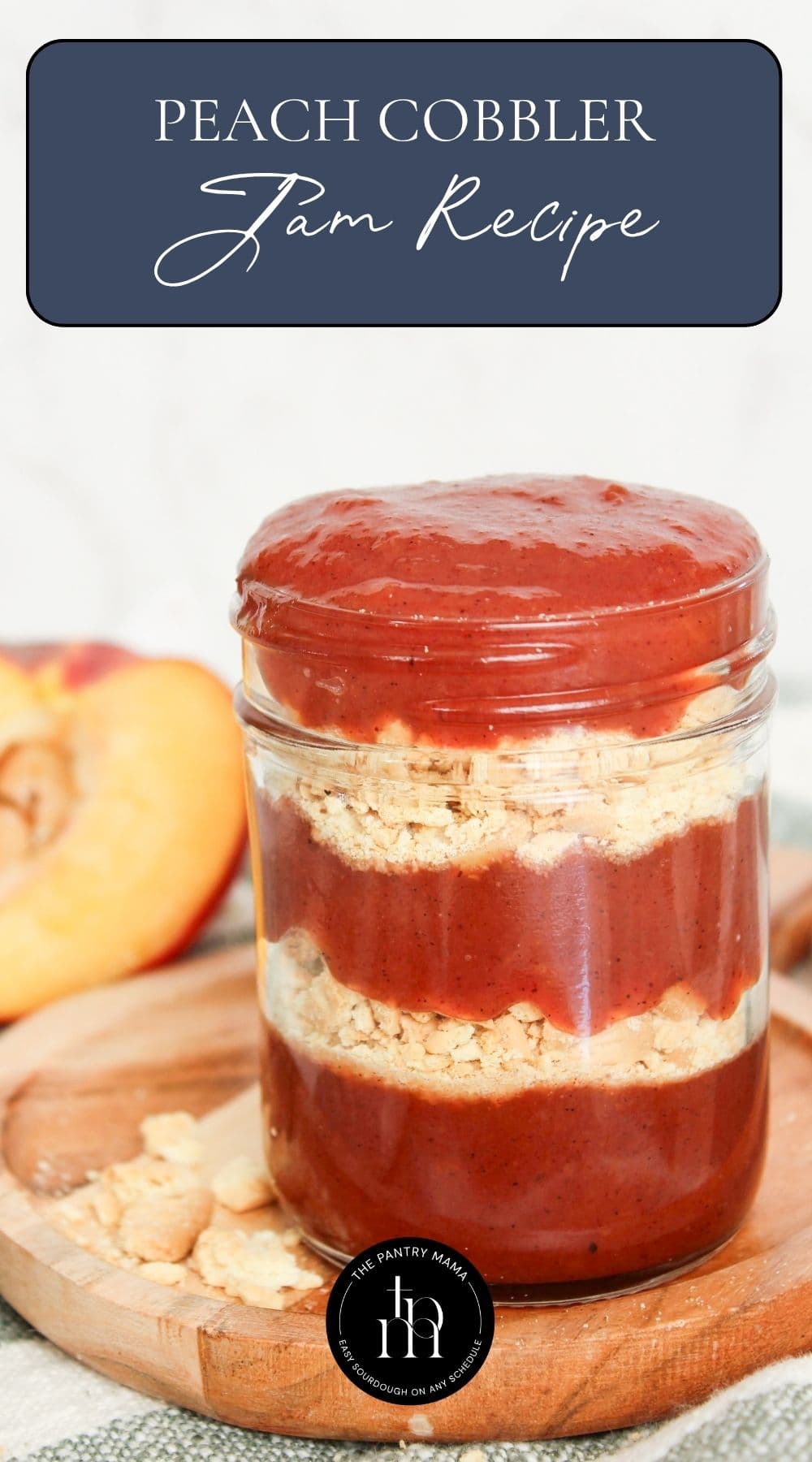 Peach cobbler jam recipe displayed in a glass jar with cookie crumb layers, fresh peaches, and recipe title overlay.