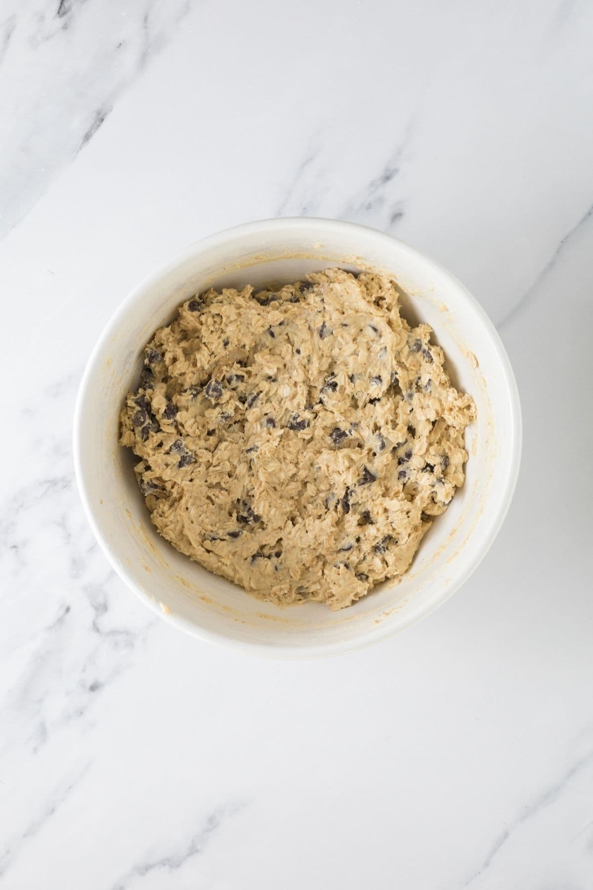 A bowl of protein sourdough chocolate chip cookie dough on the counter.