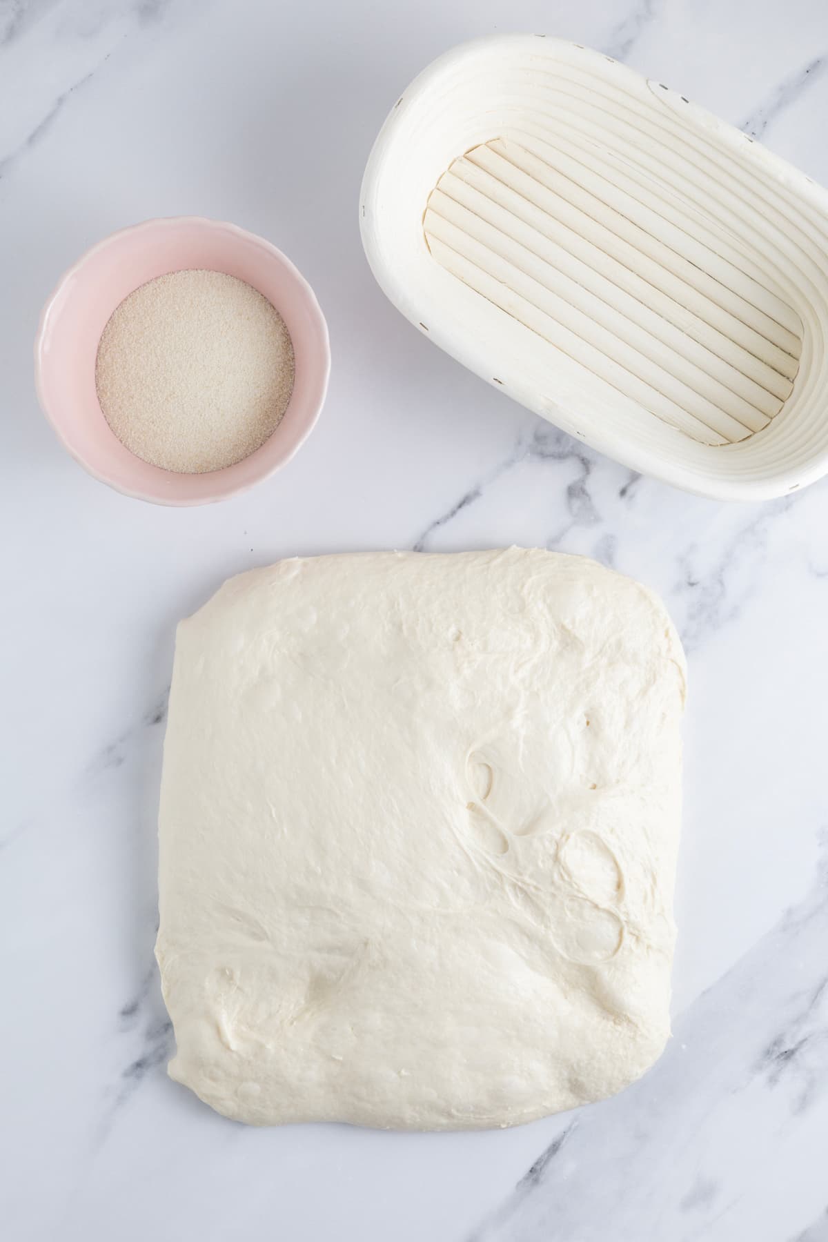 Stretching out same day sourdough bread dough on counter to begin shaping.