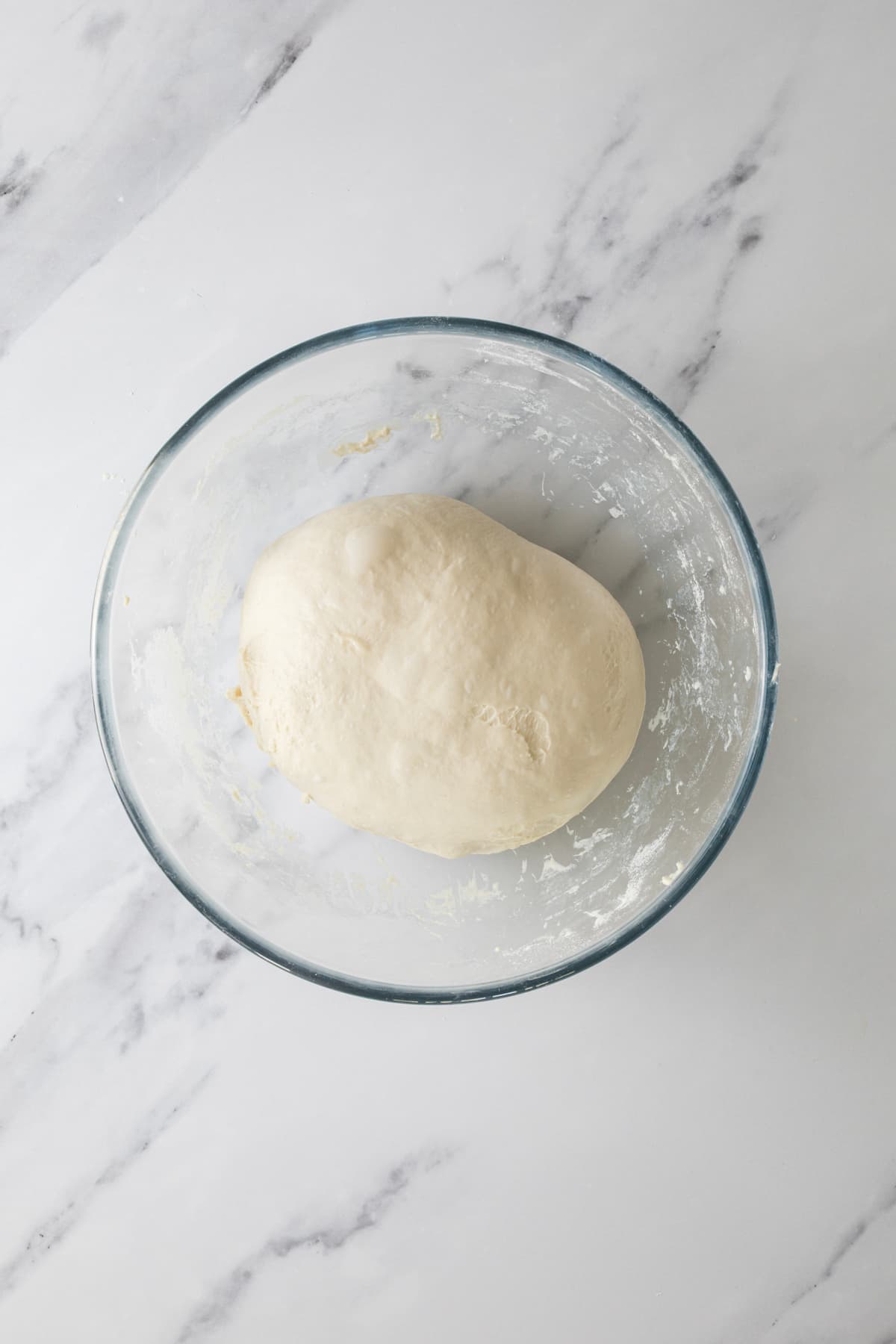 Smooth same day sourdough dough resting in a glass bowl after stretch and folds.