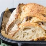 Freshly baked same day sourdough bread sliced in a cast iron bread pan.