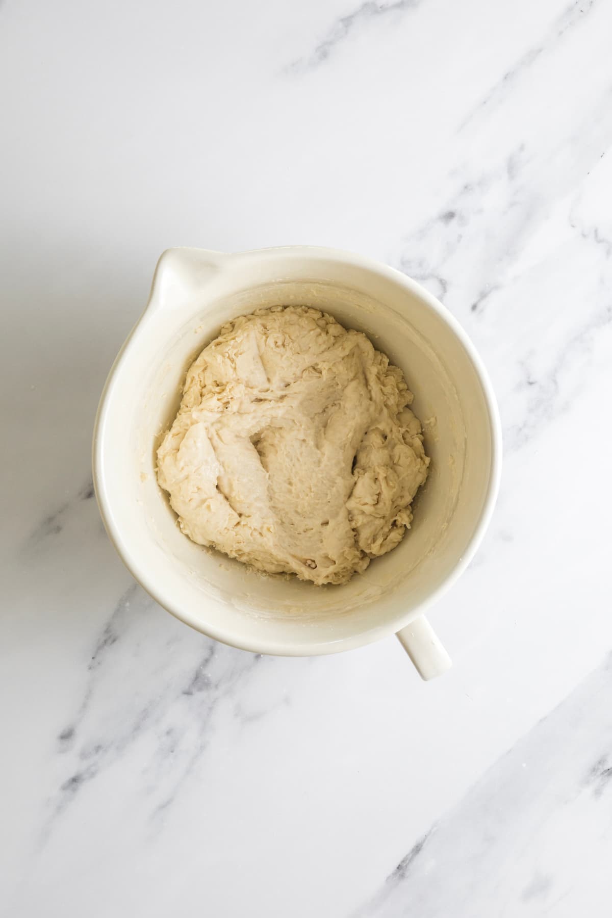 Shaggy small batch sourdough bread dough resting in a ceramic mixing bowl after the initial mix.