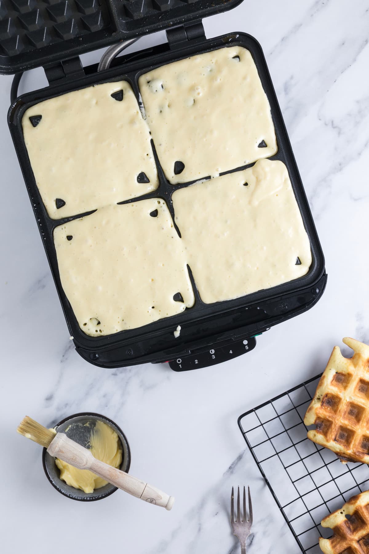 Sourdough discard waffle batter poured into a waffle iron before cooking.