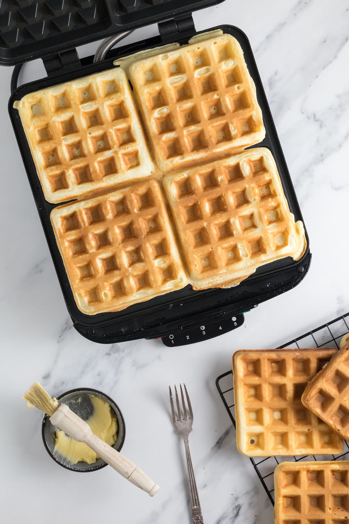 Sourdough discard waffle batter cooking in a waffle maker.