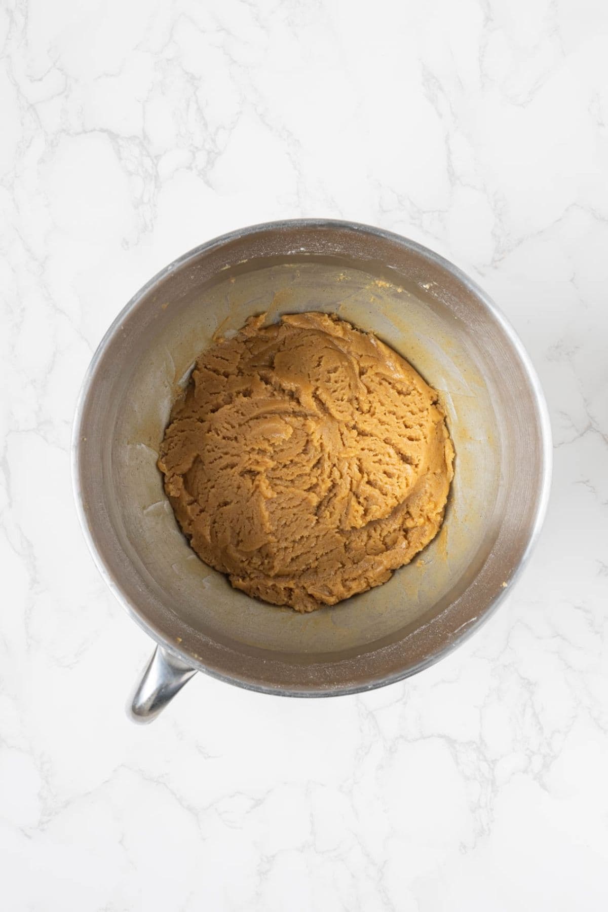 Peanut butter cookie dough mixed with sourdough starter in a stand mixer bowl.