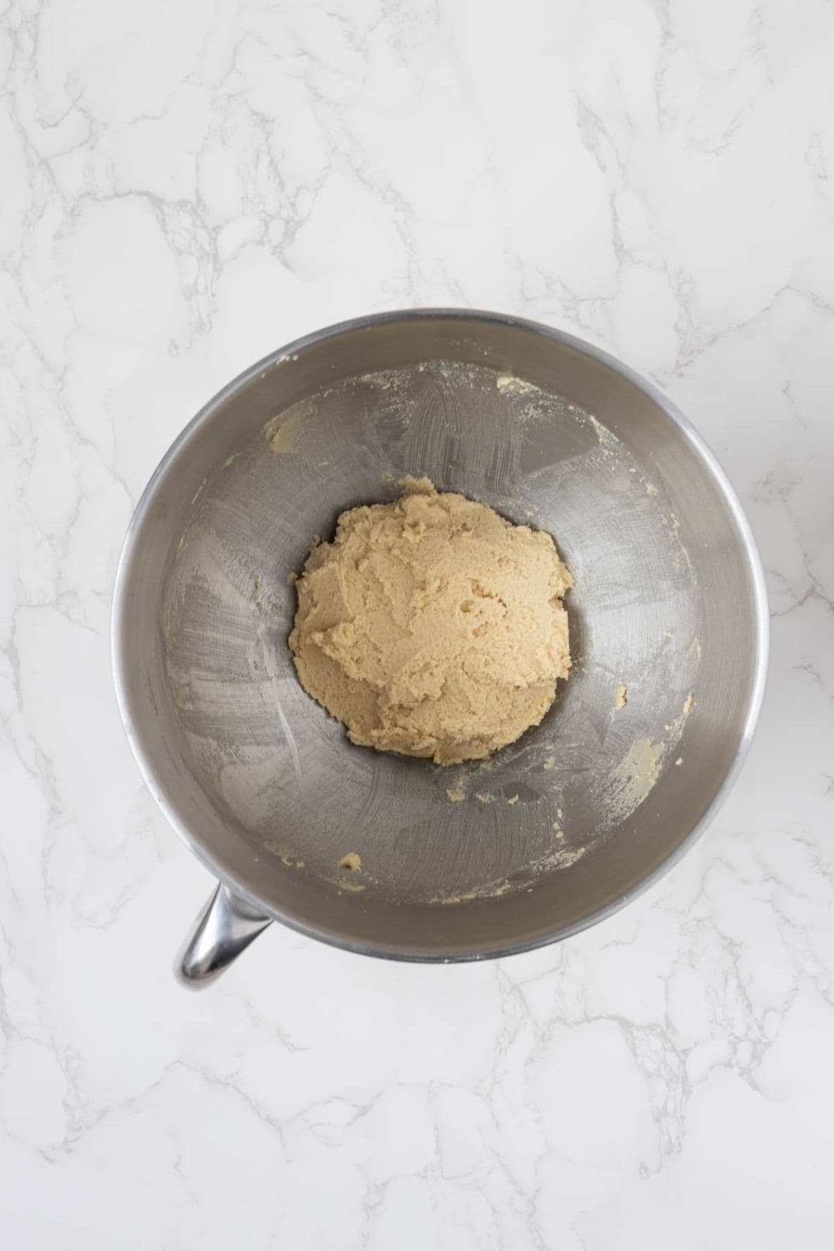 Butter and sugars creamed together in a mixing bowl for sourdough peanut butter blossom cookies.