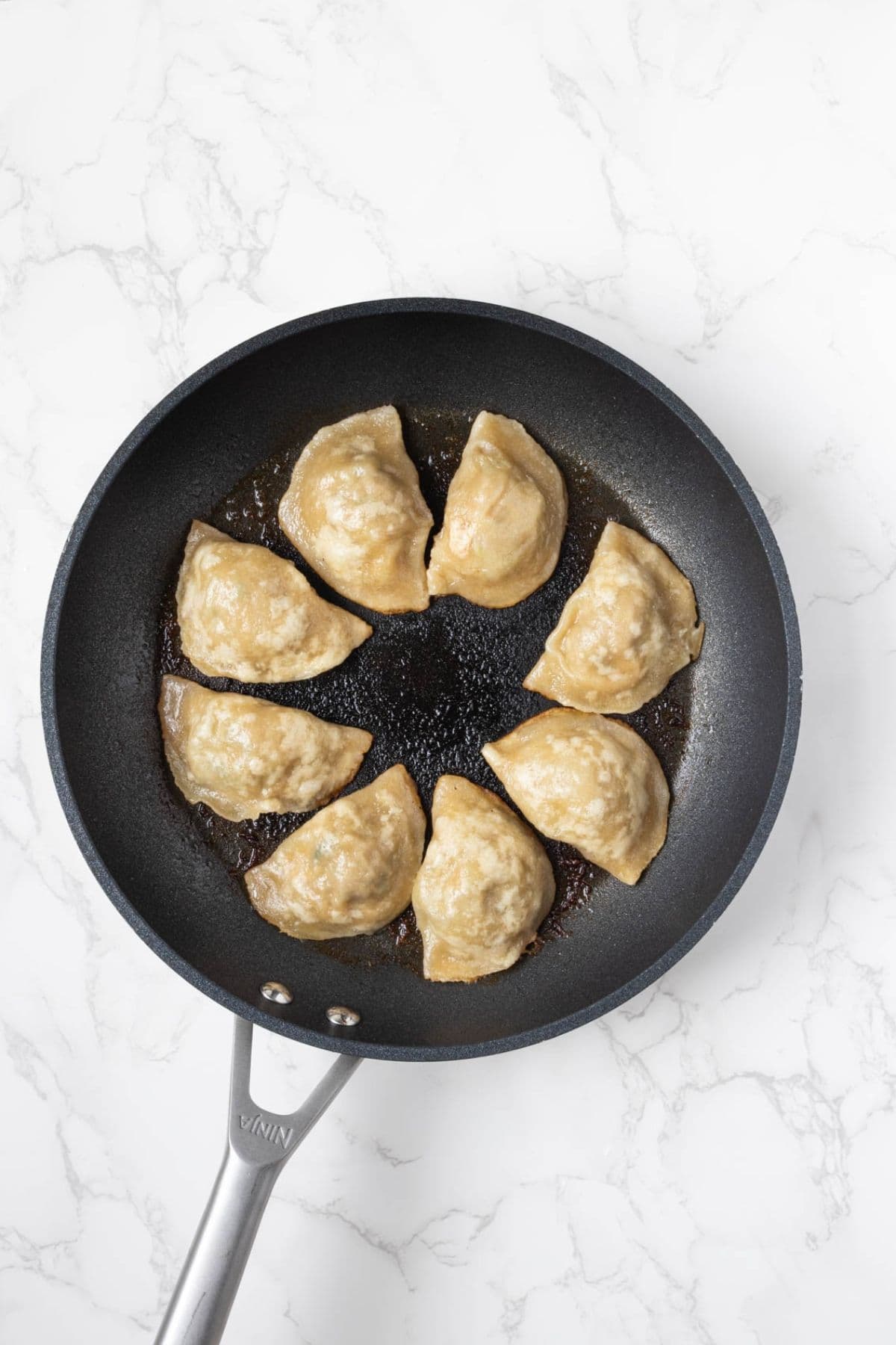 Sourdough potstickers after steaming in a skillet.