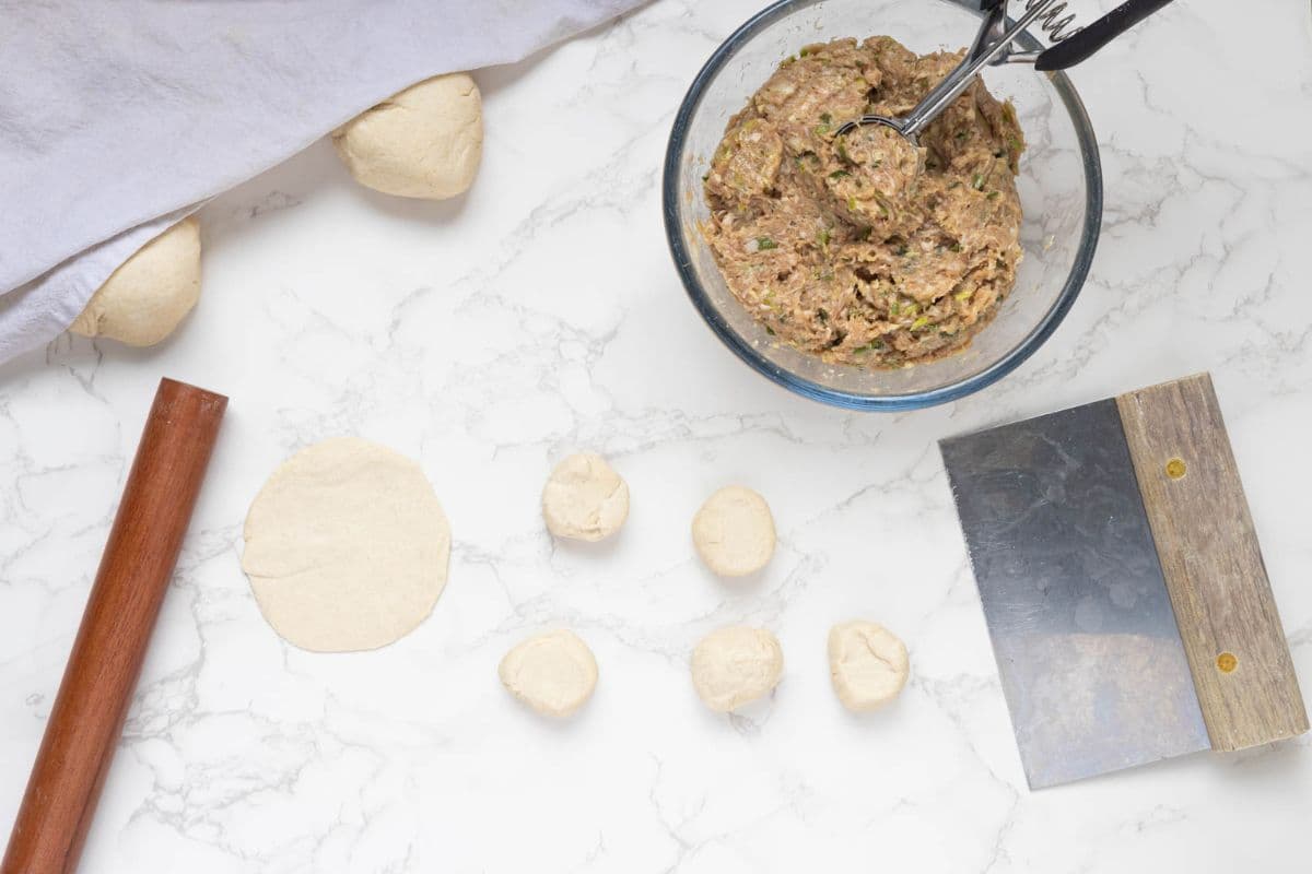 Rolling out sourdough potstickers dough to add fillings.