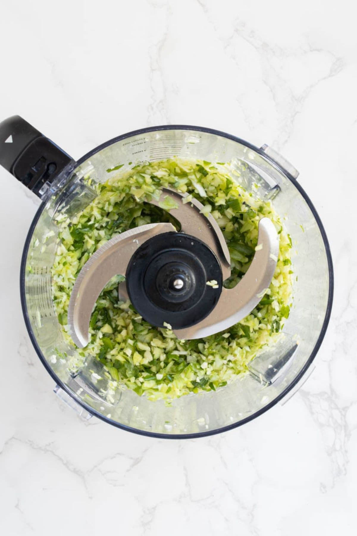 Chopped vegetables in a food processor for homemade sourdough potsticker filling.
