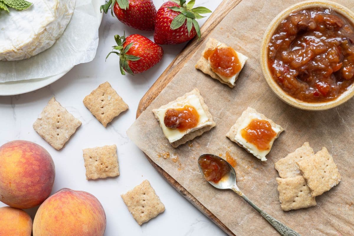Summer fruits relish served on crackers with creamy cheese, fresh strawberries, and peaches.