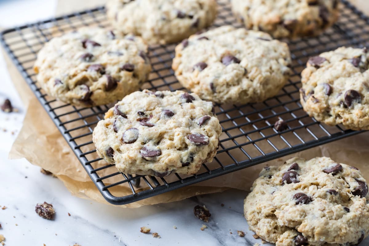 Large protein boosted sourdough chocolate chip cookies spread across a cooling rack.