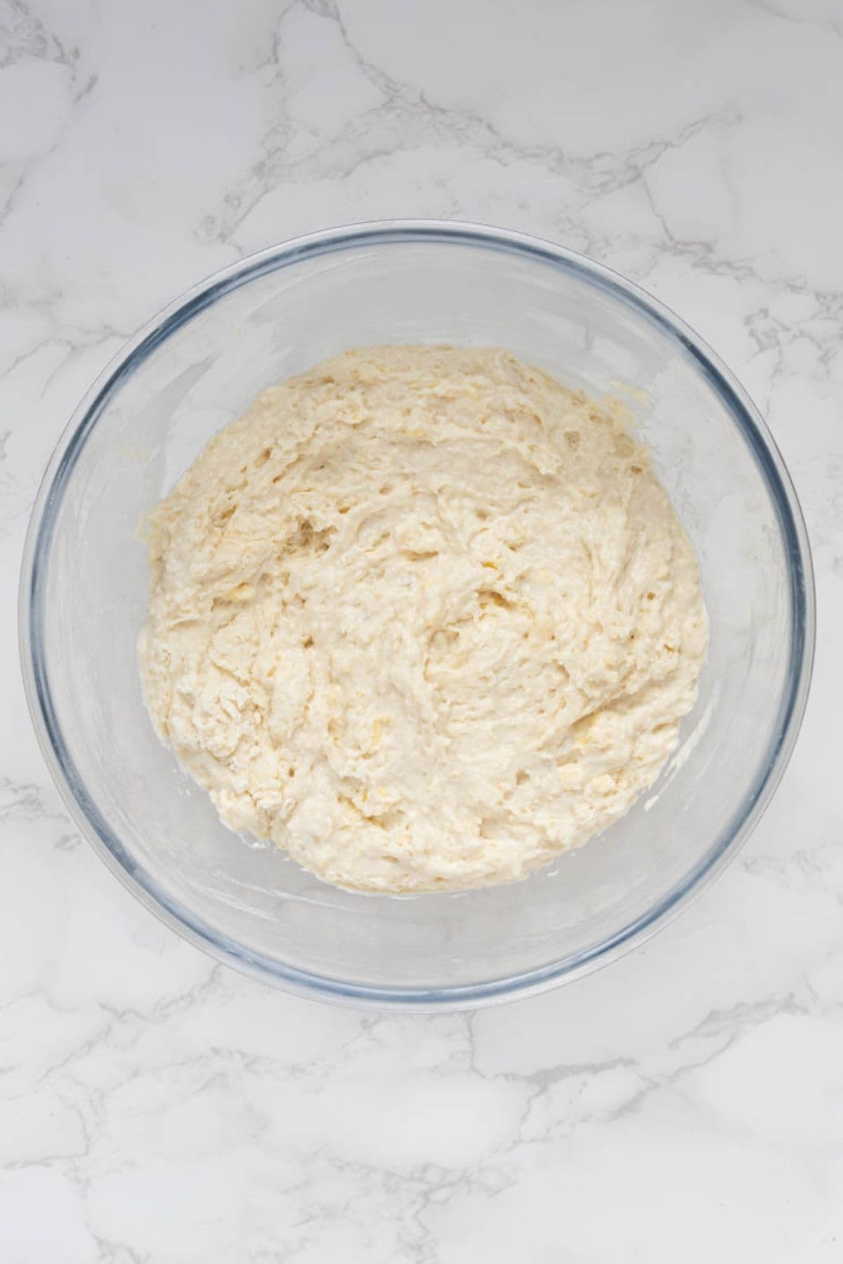 Mixed sourdough cobbler topping batter in a glass mixing bowl before assembly.