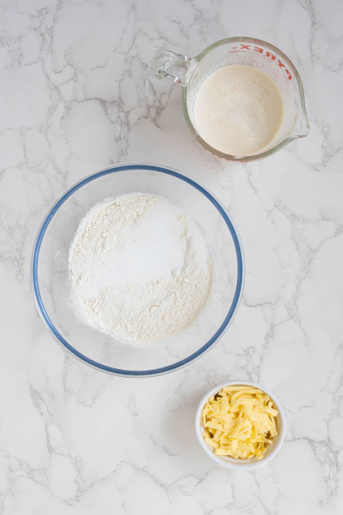 Flour, sugar, butter, and sourdough starter measured and prepared for making sourdough cobbler topping.
